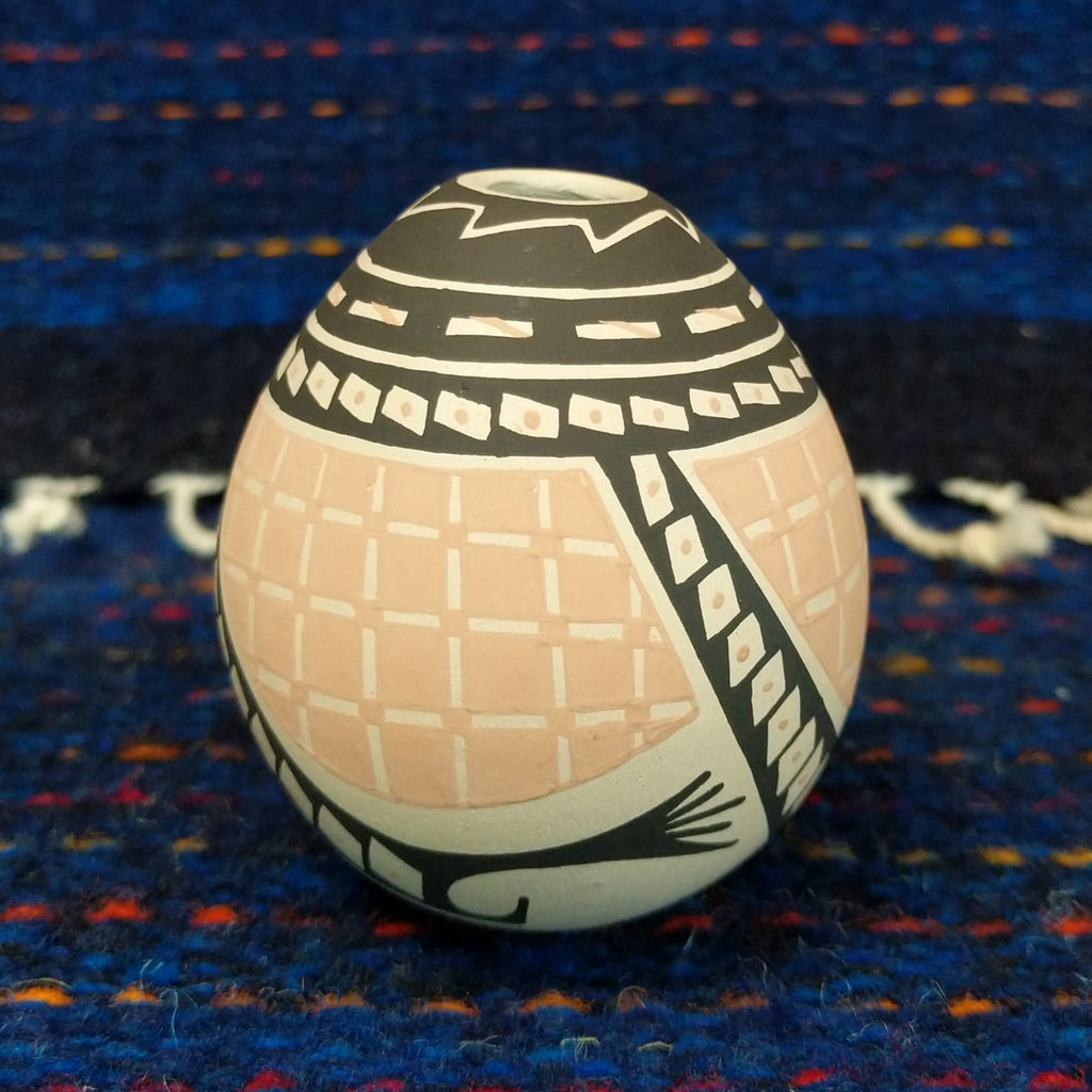 Black, white, and tan geometic patterns on the seed pot.