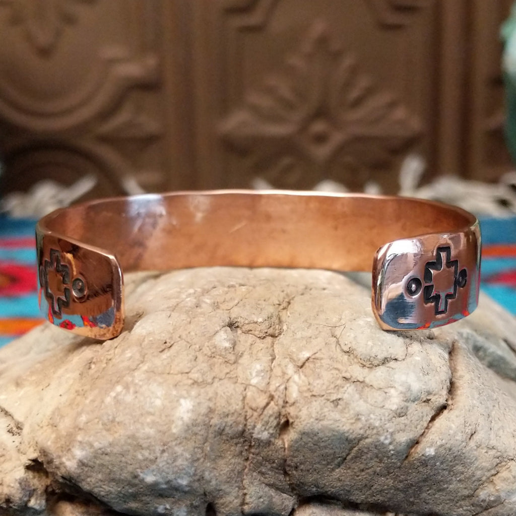 Copper and sterling silver cuff with intricate triangular stamping and polished finish.