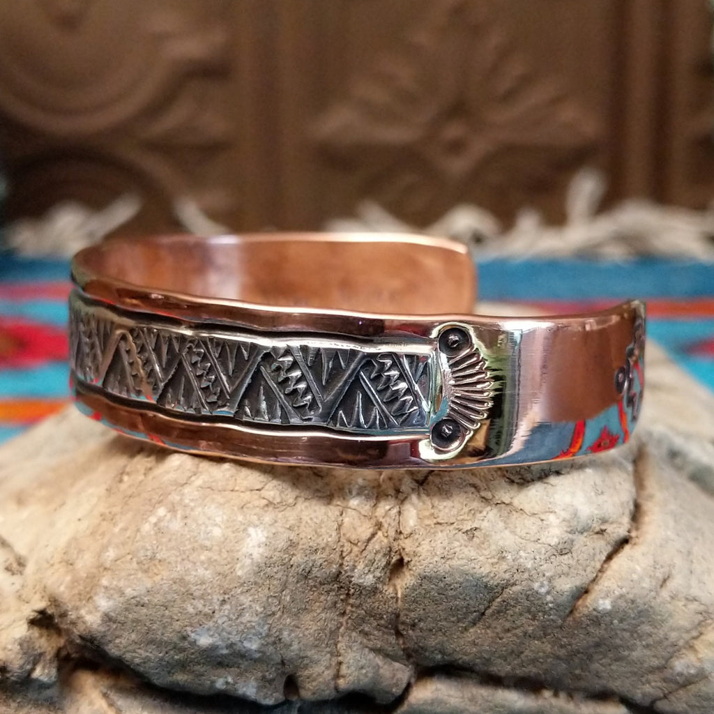 Copper and sterling silver cuff with intricate triangular stamping and polished finish.