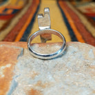 Rear view of a silver ring by Diane Wylie showing two parallel bars of unequal height decorated with repeating triangular impressions and darkened detailing.