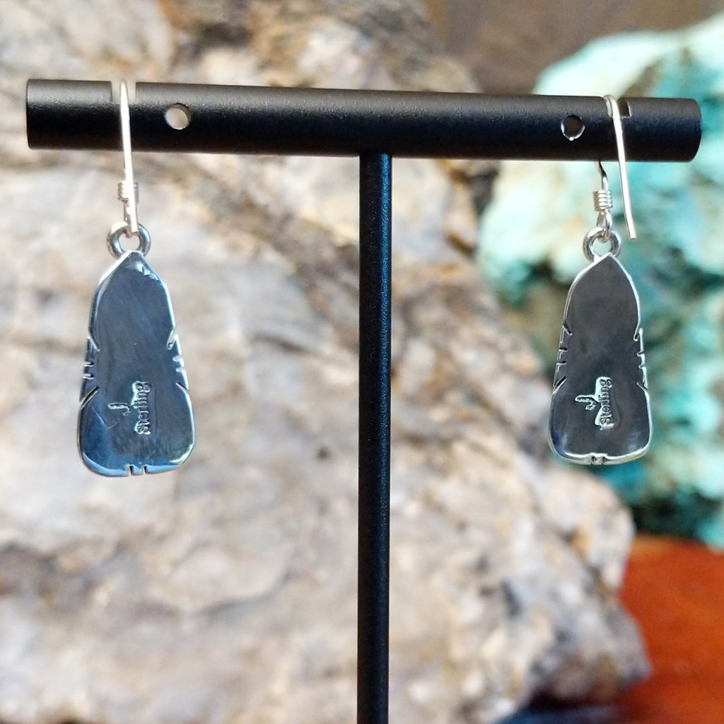 The back of the earrings feature the artisan's stamped initial.