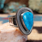 Sterling silver ring with triangular turquoise and twisted rope bezel.