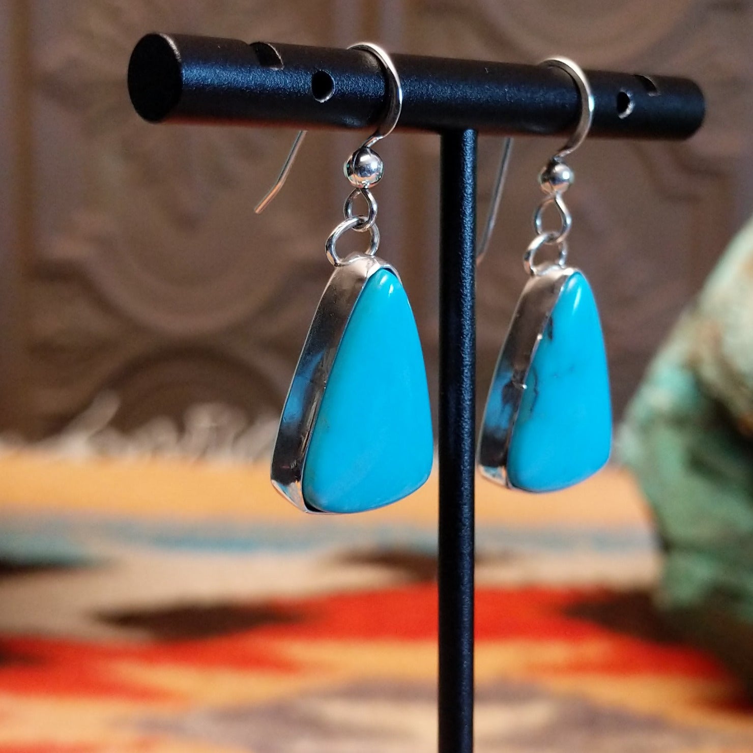 Triangular sterling silver dangle earrings with Kingman turquoise set in the bezels.