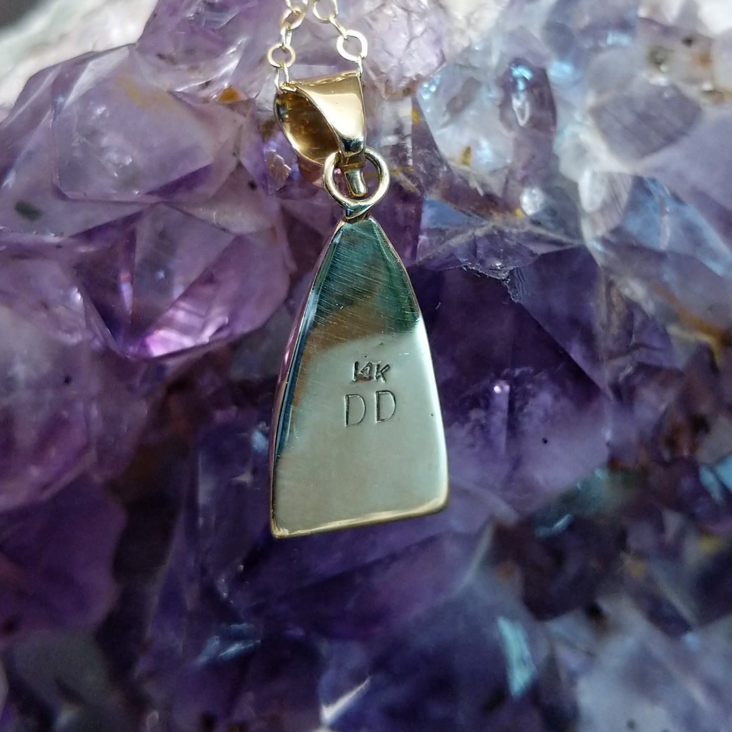 Close up of artist's stamped signature and 14K indicating 14 karat gold construction.