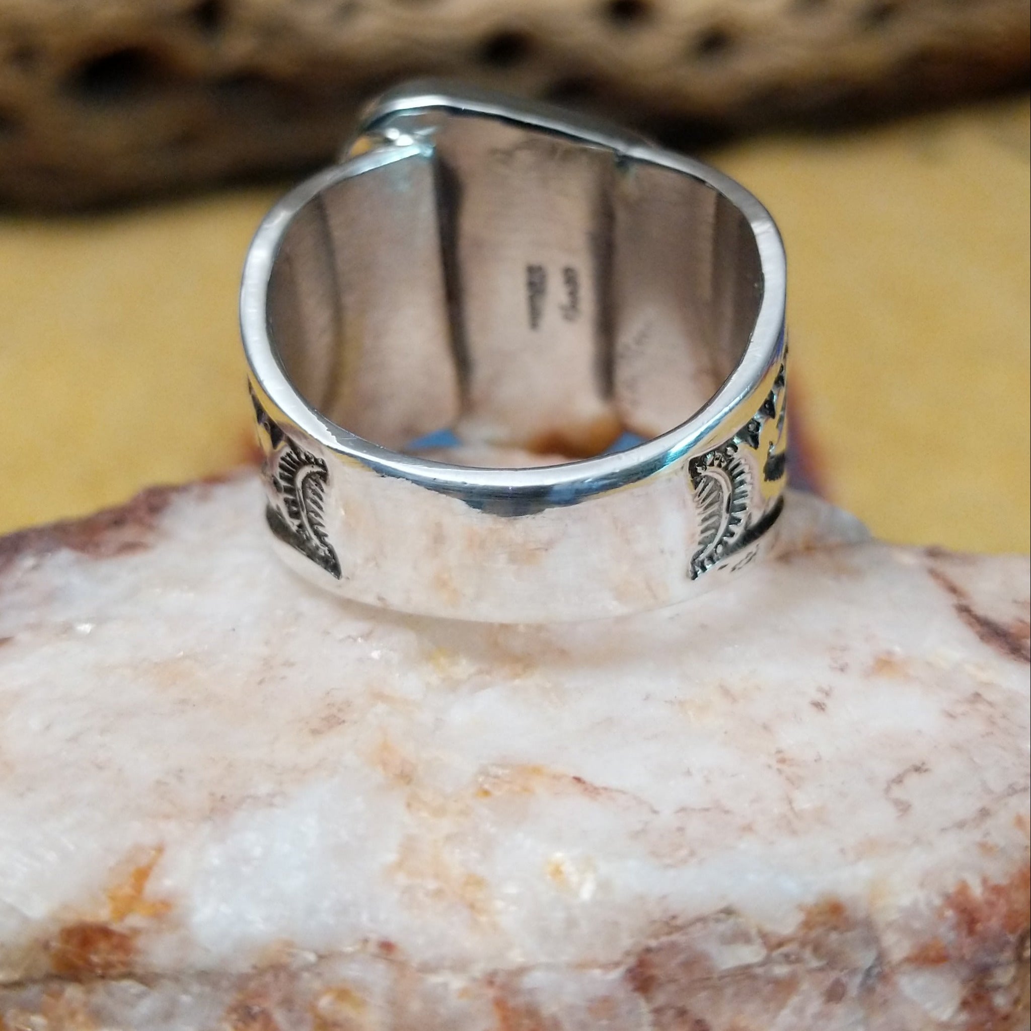 Triangular turquoise ring by E. Piaso, featuring a vibrant blue turquoise stone with natural matrix set in a handcrafted sterling silver band.  Underside view.