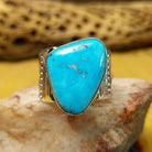Triangular turquoise ring by E. Piaso, featuring a vibrant blue turquoise stone with natural matrix set in a handcrafted sterling silver band.