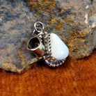 White buffalo set in a notched sterling silver bezel with intricately dotted frame.