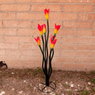A large metal tulip sculpture, with painted vivid orange petals.