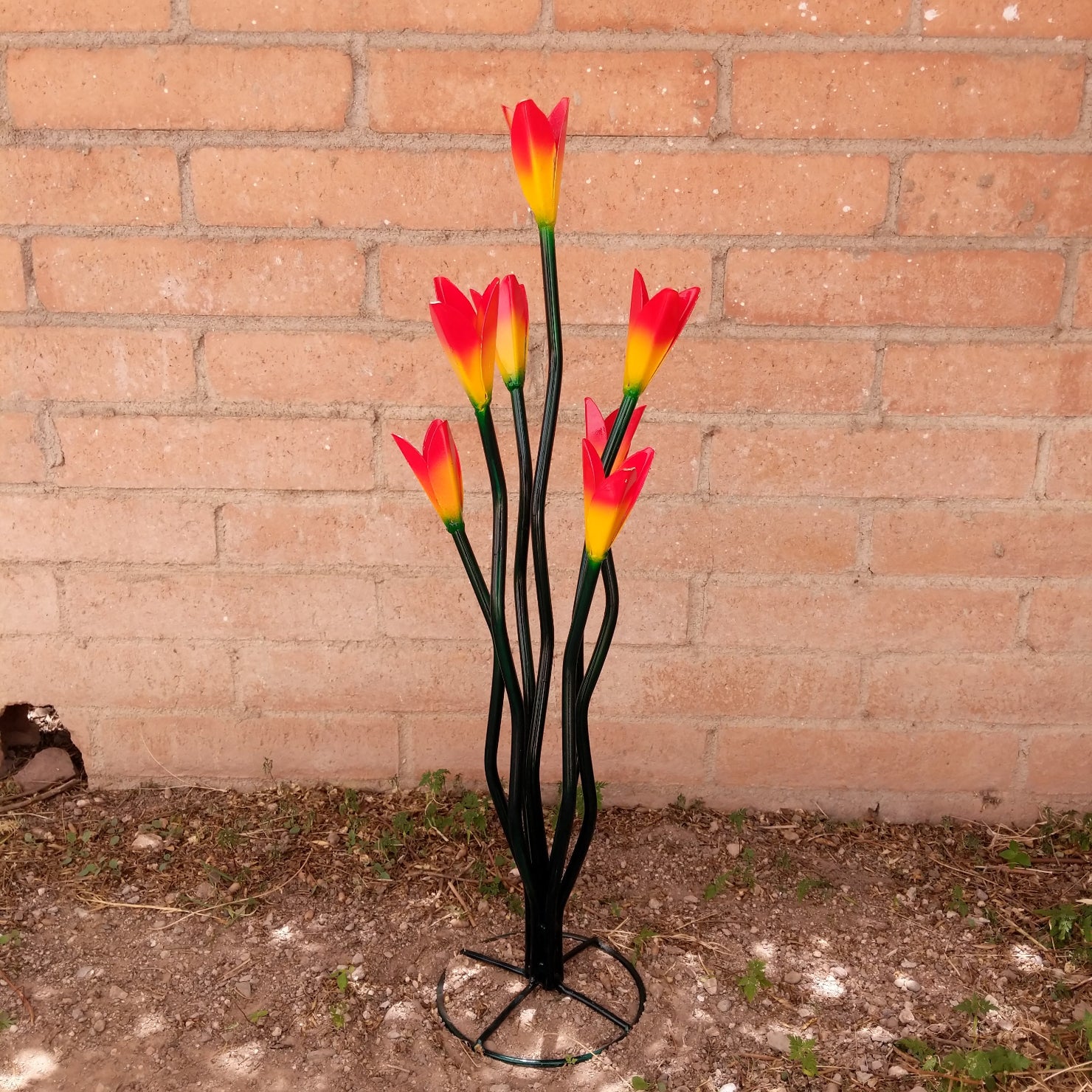 A large metal tulip sculpture, with painted vivid orange petals.