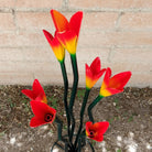 Close-up reveals the glossy orange finish and subtle yellow accents of the petals.