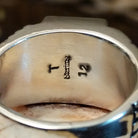 Close-up of the artisan's stamped signature.