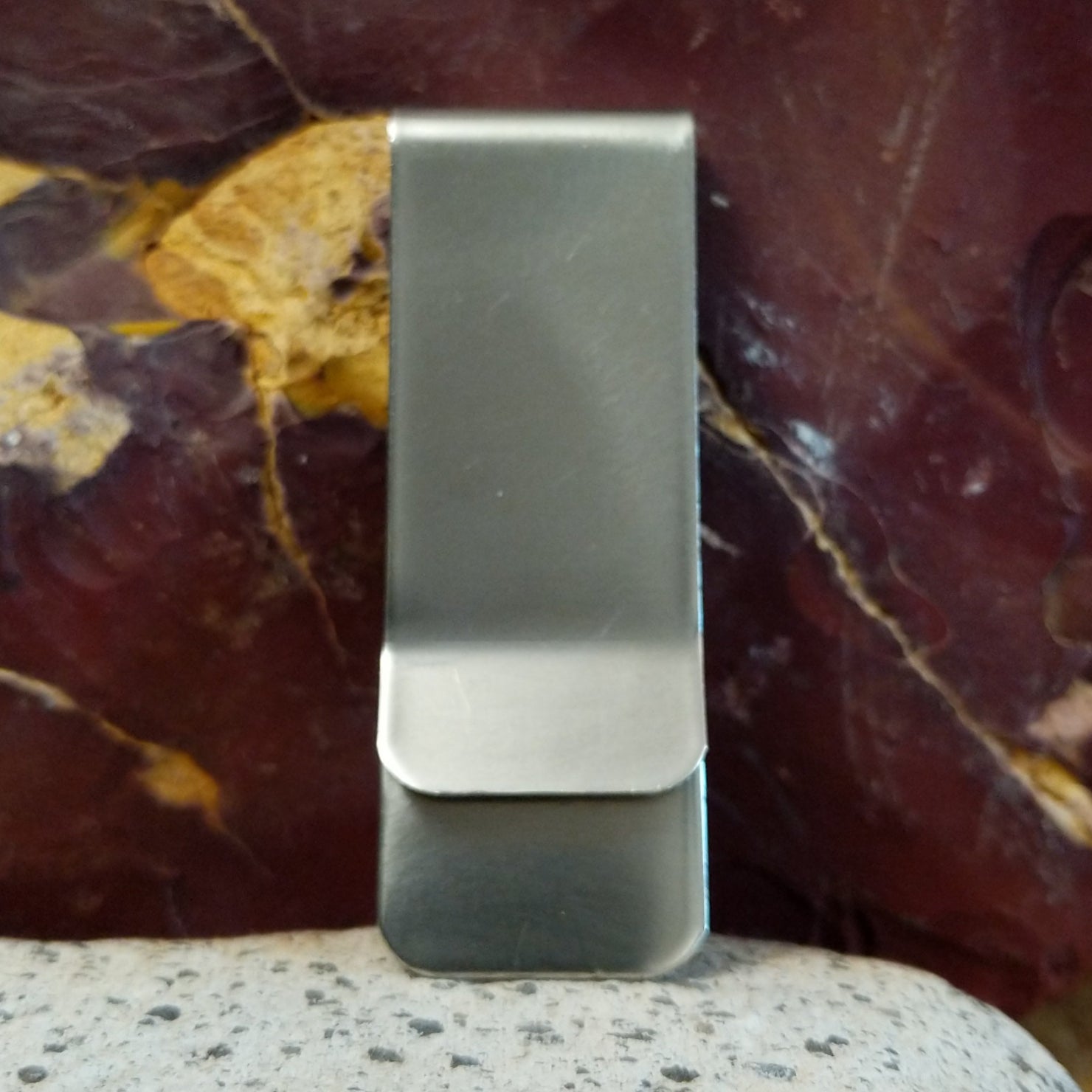 The smooth stainless steel backing of the money clip.