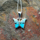 Handcrafted sterling silver turquoise butterfly pendant by Valerie Yazzie, featuring different shades of turquoise inlay in a butterfly design.
