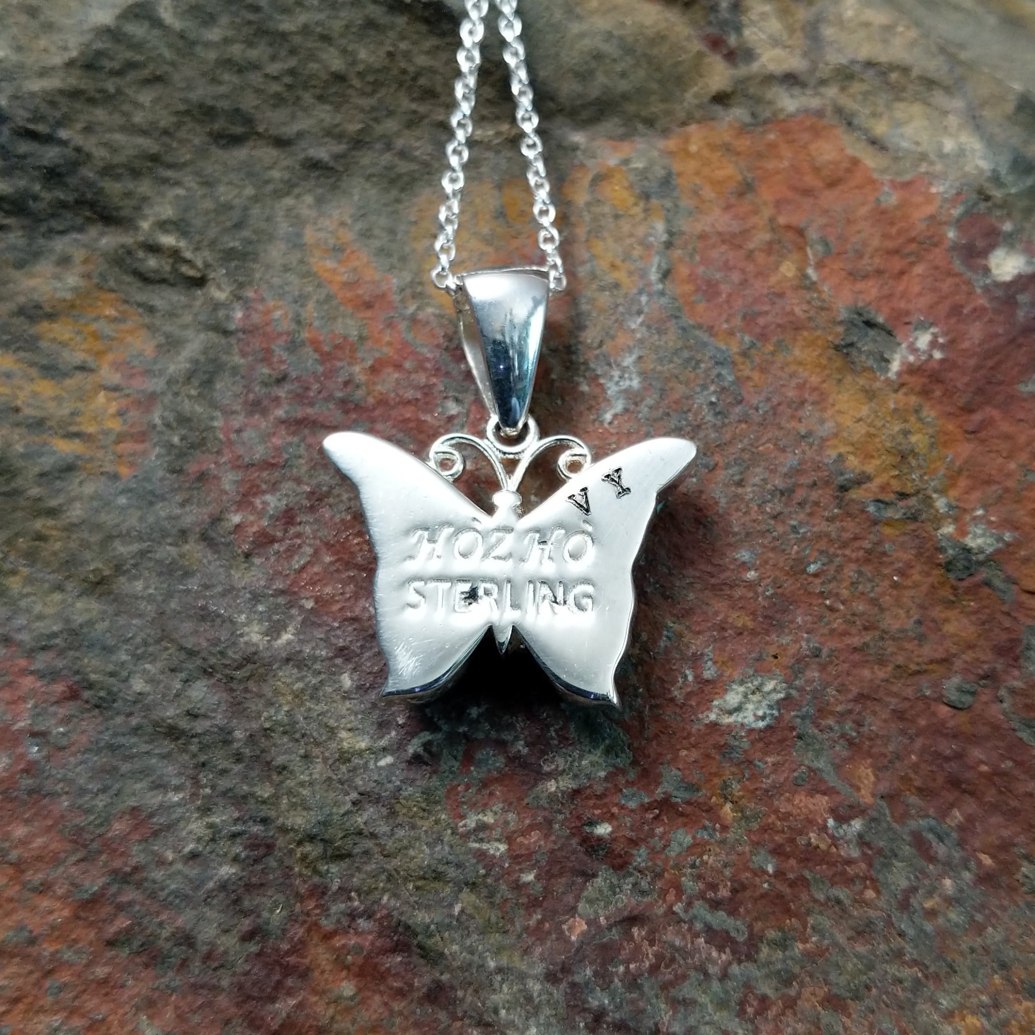 Handcrafted sterling silver turquoise butterfly pendant by Valerie Yazzie, featuring different shades of turquoise inlay in a butterfly design; artisan and Sterling Silver stamp.