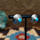 Sterling silver earrings with turquoise set in round bezels, framed by stamped setting. 