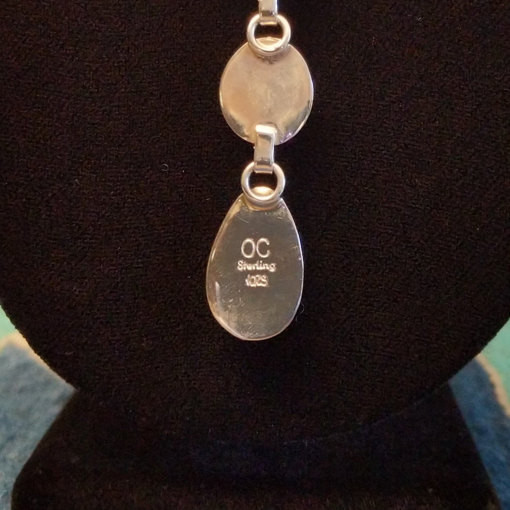 Close-up of the artisan's signature on the necklace.