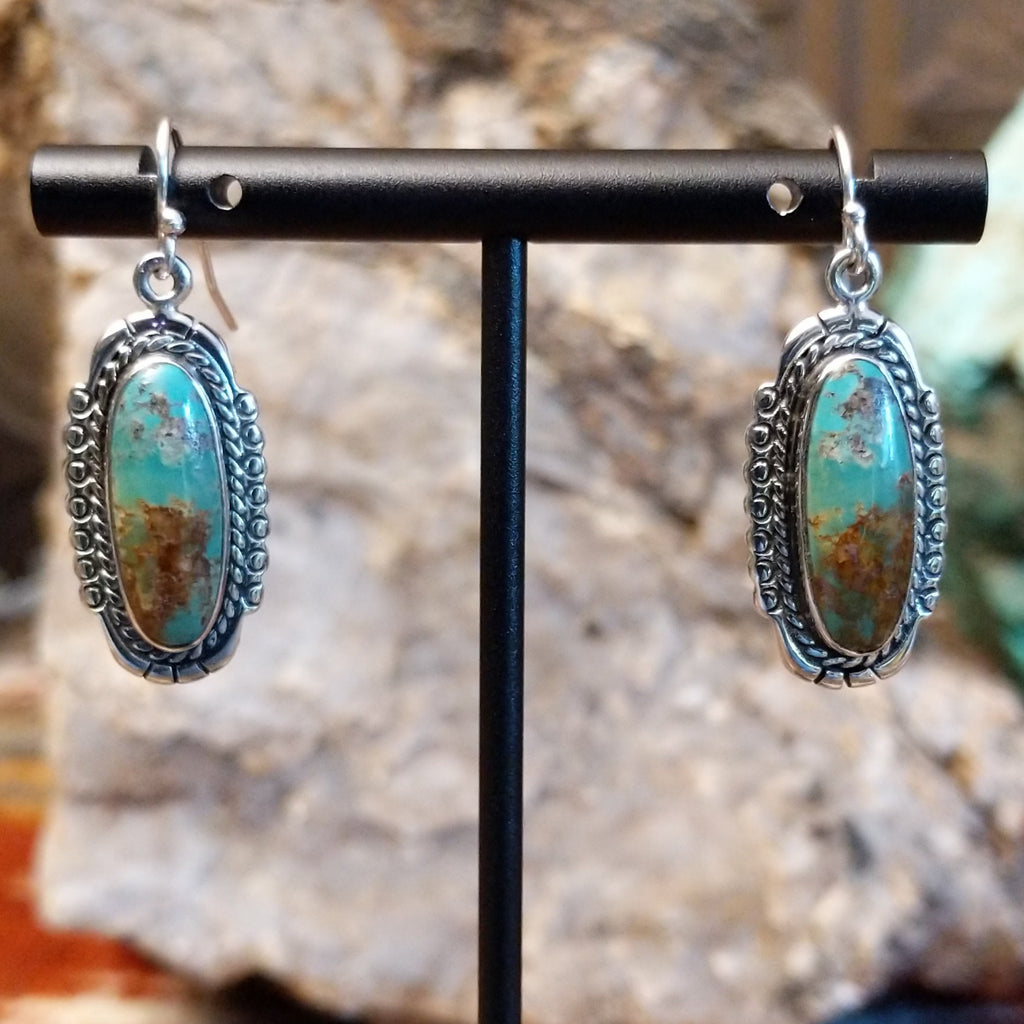 Turquoise set in sterling silver bezels with twisted rope and dotted accents.