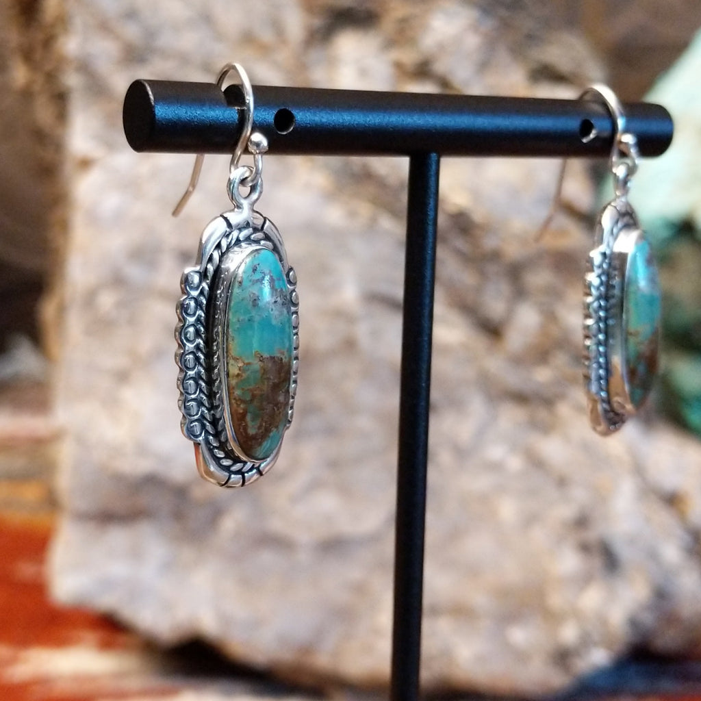 Turquoise set in sterling silver bezels with twisted rope and dotted accents.