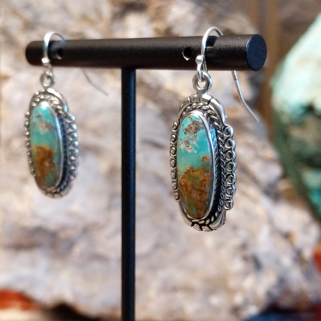 Turquoise set in sterling silver bezels with twisted rope and dotted accents.