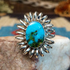 Sterling silver ring with turquoise set in the large oval bezel, framed by coiled silverwork.