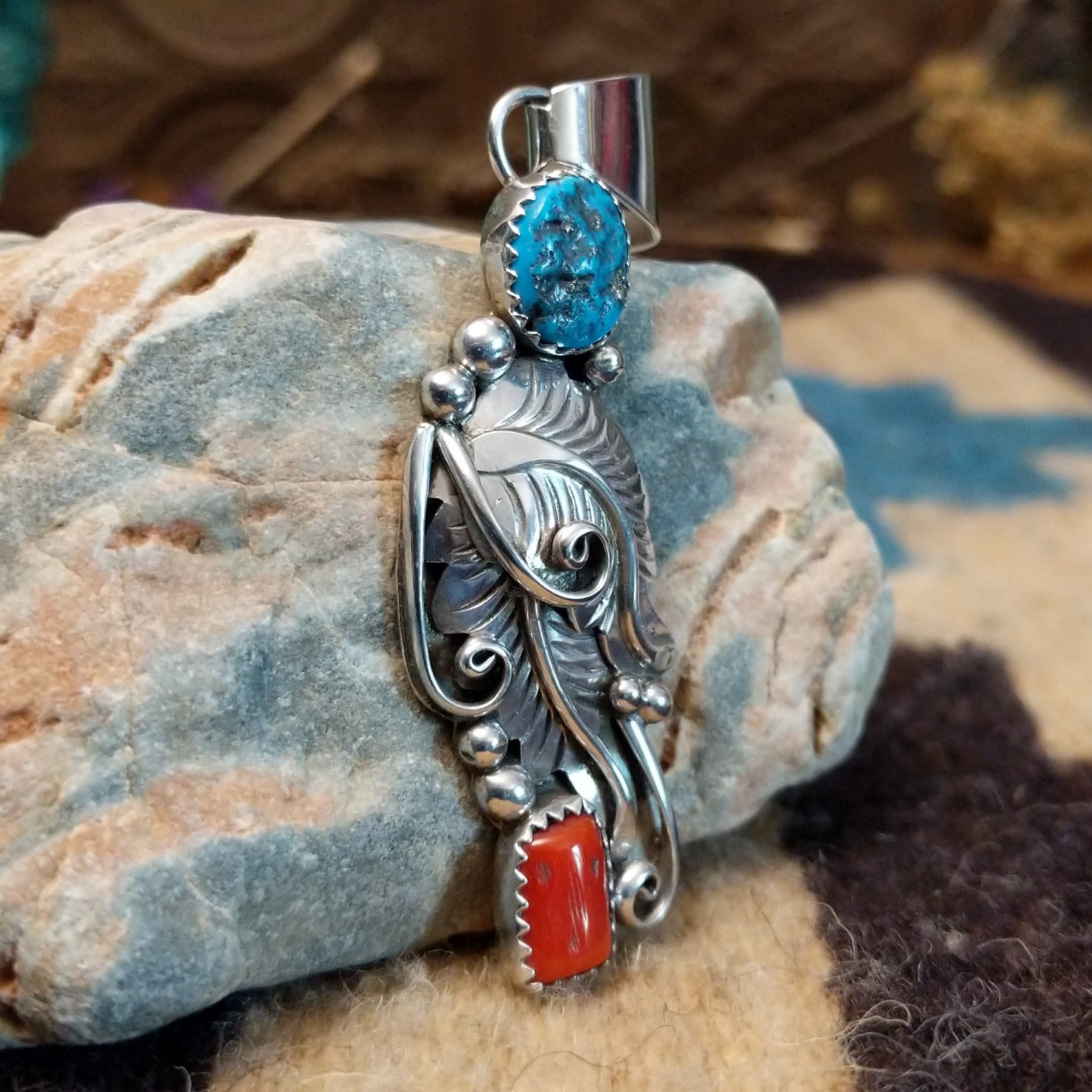 Sterling silver pendant with turquoise and coral set in notched bezels and feather silverwork.