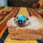 Turquoise & Coral Snake Ring by Effie Calavaza featuring turquoise and coral stones, a decorative silver snake motif with turquoise accents, sawtooth bezels, and a polished silver band.