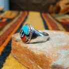 Turquoise & Coral Snake Ring by Effie Calavaza featuring turquoise and coral stones, a decorative silver snake motif with turquoise accents, sawtooth bezels, and a polished silver band; side view.