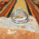 Turquoise & Coral Snake Ring by Effie Calavaza featuring turquoise and coral stones, a decorative silver snake motif with turquoise accents, sawtooth bezels, and a polished silver band; underside view.