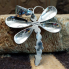 Silver dragonfly pendant with turquoise stones by Darrin Livingston. Back view showing artisan signature.