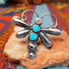 Turquoise Dragonfly Ring by Tim Yazzie featuring two turquoise stones set in Sterling Silver with polished wings, curled antennae, and dimensional silver accents.