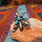 Turquoise Dragonfly Ring by Tim Yazzie featuring two turquoise stones set in Sterling Silver with polished wings, curled antennae, and dimensional silver accents; side view.