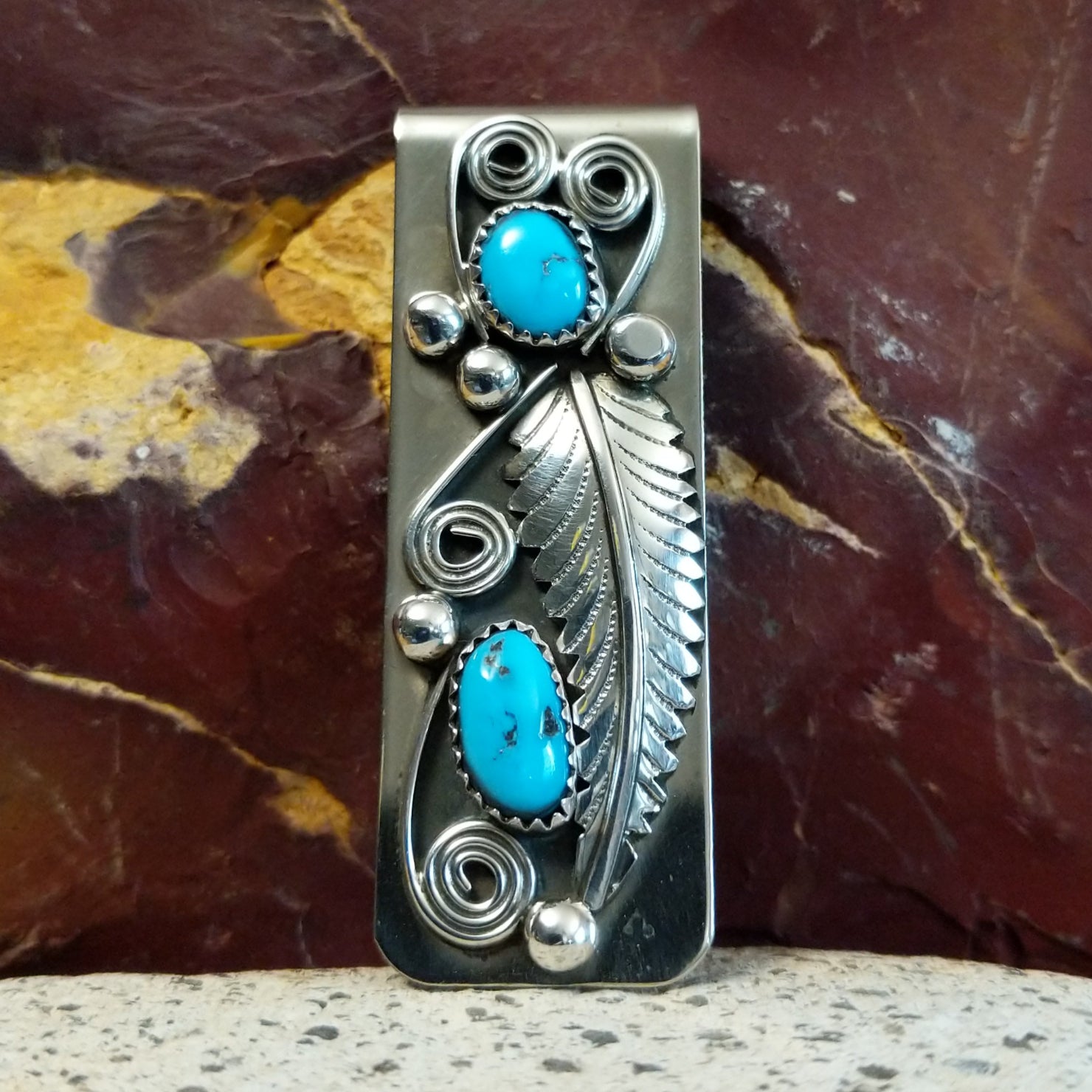 Turquoise feather money clip with two turquoise stones in silver bezels.