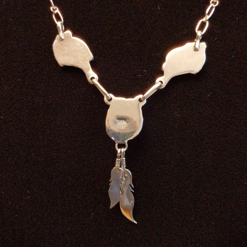The polished backings on the pendant and feathers.