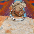 Turquoise Feather Ring by Harry B. Yazzie featuring two turquoise stones set in Sterling Silver with detailed feathers, a silver flower, scrollwork, and polished bead accents; underside view.