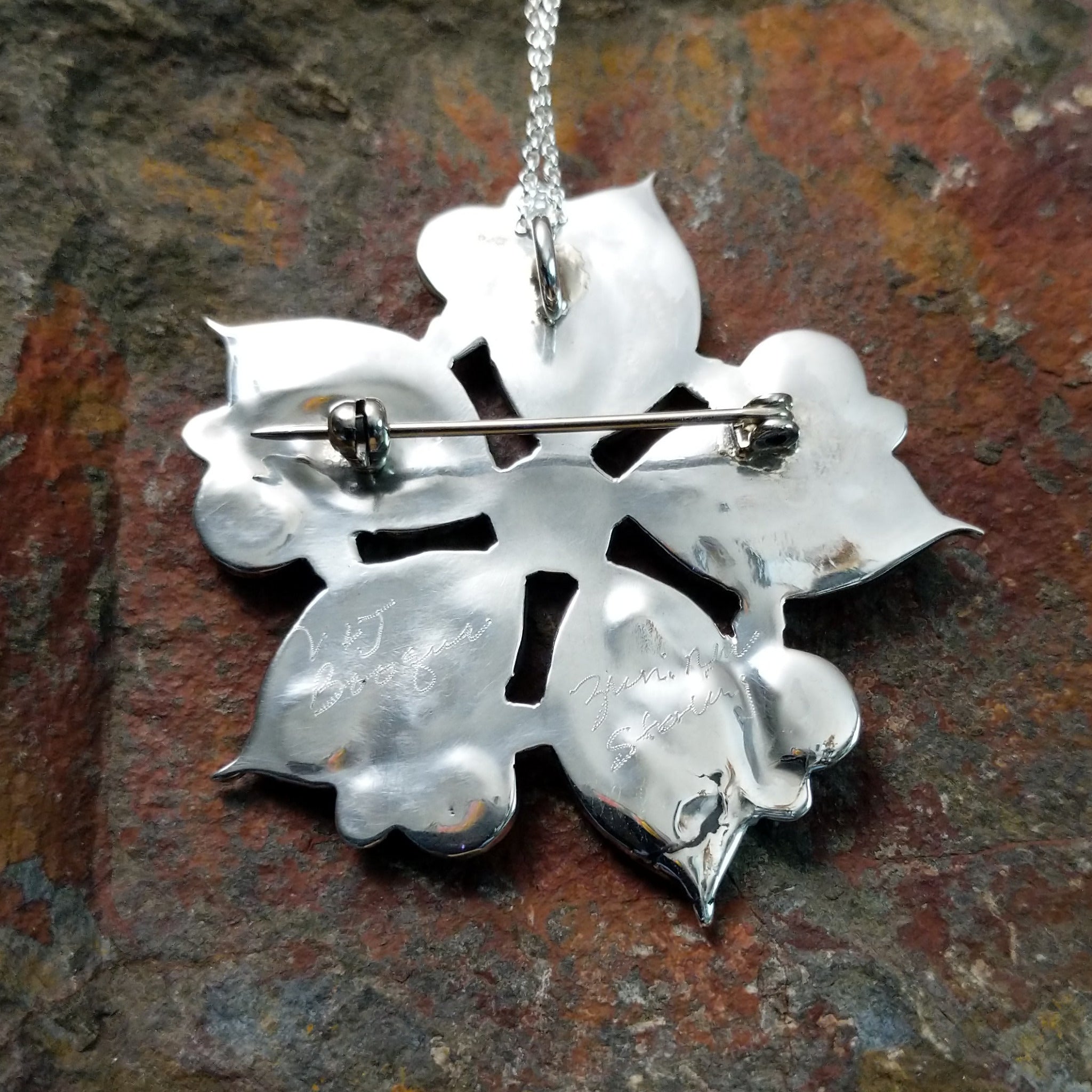 Handcrafted sterling silver turquoise flower pin and pendant by V. Booqua, featuring turquoise cabochons in a stylized floral design; artisans signatures.