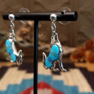 Sterling silver coyote earrings with turquoise set in the bezels.