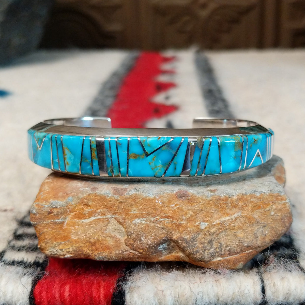 Silver cuff by Raymond Coriz featuring vibrant turquoise inlay with natural matrix and intricate geometric silver channel designs.