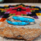 Turquoise inlay hoop earrings by Keme Peina with silver line details.