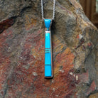 Turquoise inlay pendant by Stacy Spencer featuring an elongated geometric design with vibrant turquoise sections set in polished sterling silver and a turquoise-inlaid bail.