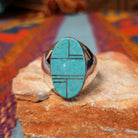 Turquoise Inlay Ring by Wilbert Grey featuring an elongated oval turquoise face with natural matrix, geometric silver channel inlay, and a polished tapered silver band.