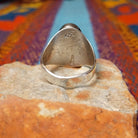 Turquoise Inlay Ring by Wilbert Grey featuring an elongated oval turquoise face with natural matrix, geometric silver channel inlay, and a polished tapered silver band; underside view.