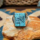 Handcrafted Navajo sterling silver ring by Wilbert Grey featuring a square turquoise mosaic inlay with natural black matrix, set in a polished bezel with a bold geometric design.