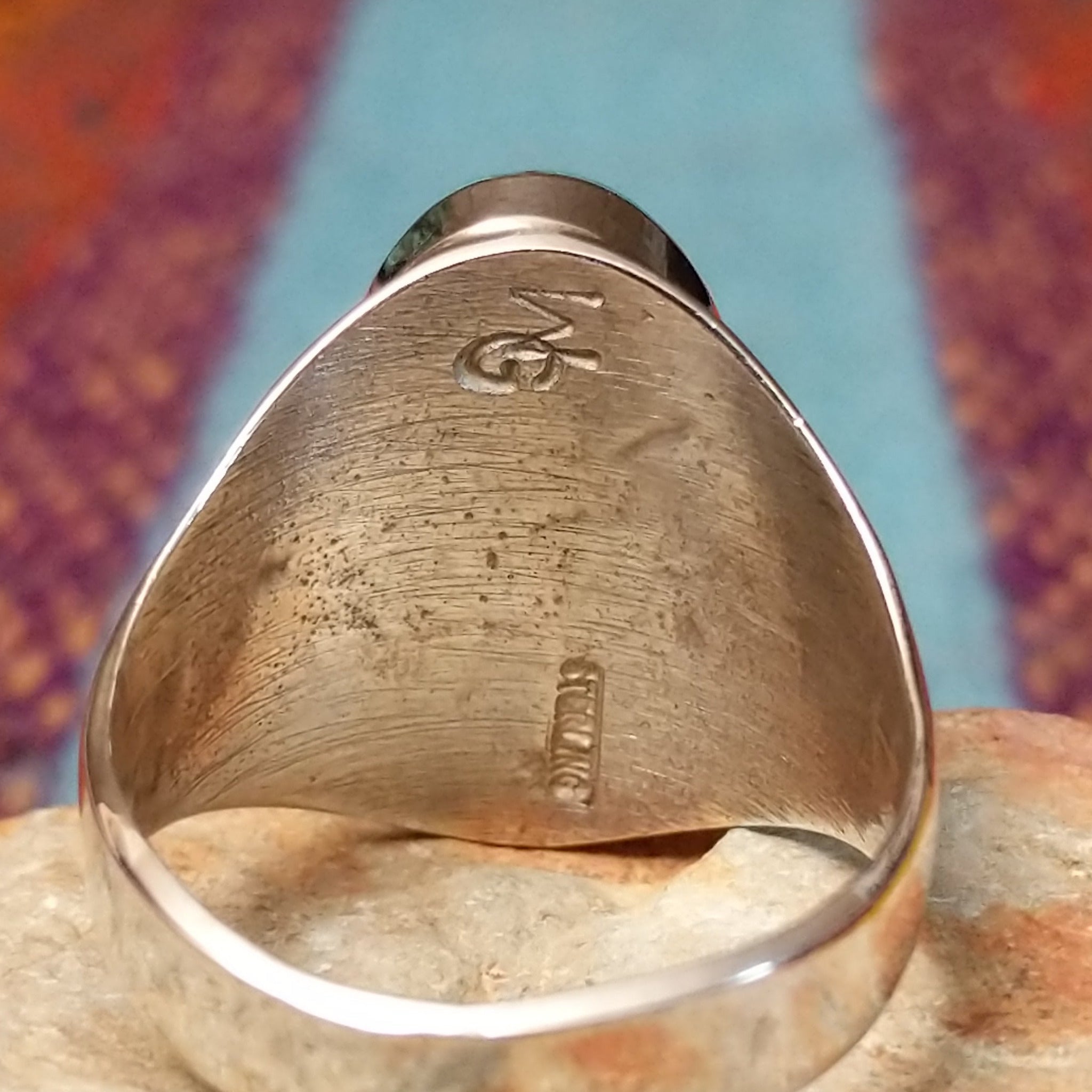 Turquoise Inlay Ring by Wilbert Grey featuring an elongated oval turquoise face with natural matrix, geometric silver channel inlay, and a polished tapered silver band; artisan and Sterling Silver stamp.
