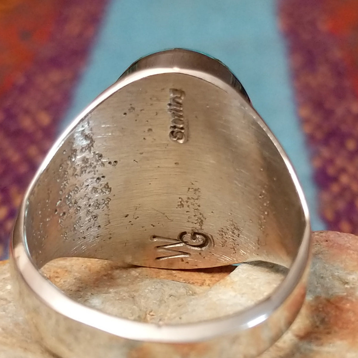 Turquoise Inlay Ring by Wilbert Grey featuring an oval turquoise face with natural brown and green matrix, divided by geometric silver channels and set in a wide polished silver band; artisan and Sterling Silver stamp.