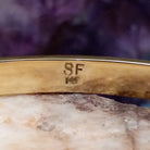 Close up of artist's stamped signature and stamped 14K, indicating 14 karat gold construction.