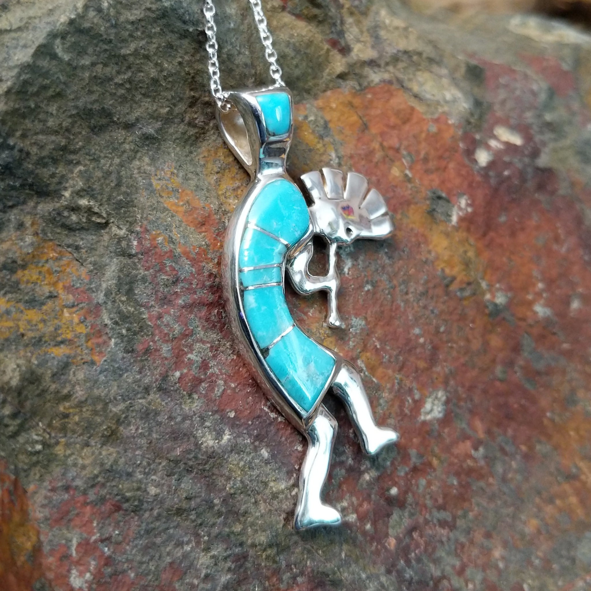Handcrafted sterling silver turquoise Kokopelli pendant by Bernadine Joe, featuring a traditional Navajo Kokopelli design; side view.