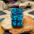 Sterling silver Navajo rectangle ring by Wilbert Grey featuring natural turquoise with black matrix and lapis lazuli geometric inlay in a polished signet-style setting.