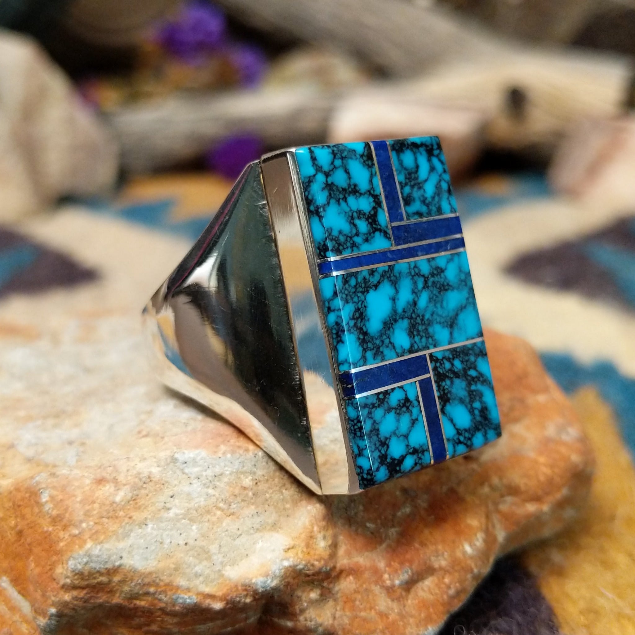 Sterling silver Navajo rectangle ring by Wilbert Grey featuring natural turquoise with black matrix and lapis lazuli geometric inlay in a polished signet-style setting; side view.