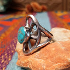 Turquoise Lattice Ring by Harry Morgan featuring an oval turquoise stone with natural matrix set in Sterling Silver, surrounded by bold sculpted lattice-style openwork; side view.