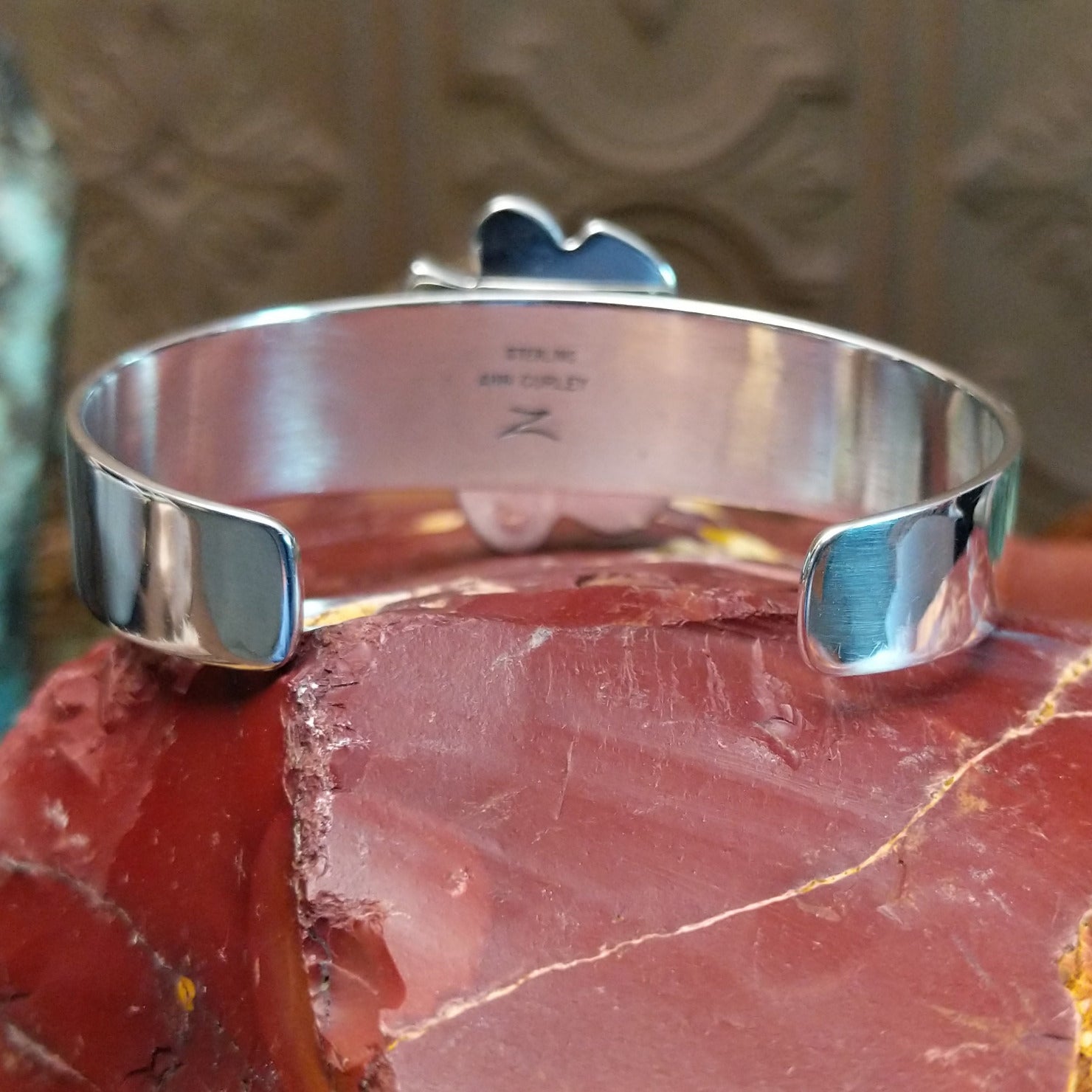 Sterling silver cuff bracelet with a cluster of turquoise set in various bezels.
